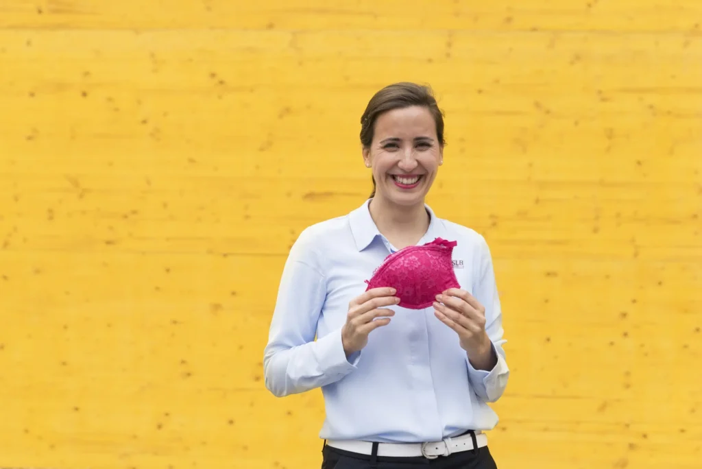 Andreia Fernandes in front of yellow Wall smiling at the audience