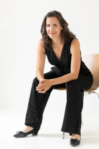 Andreia Fernandes, Expertin für Portfolio Careers, Leadership und Entrepreneurship, sitzt entspannt auf einem Sofa und blickt in die Kamera.